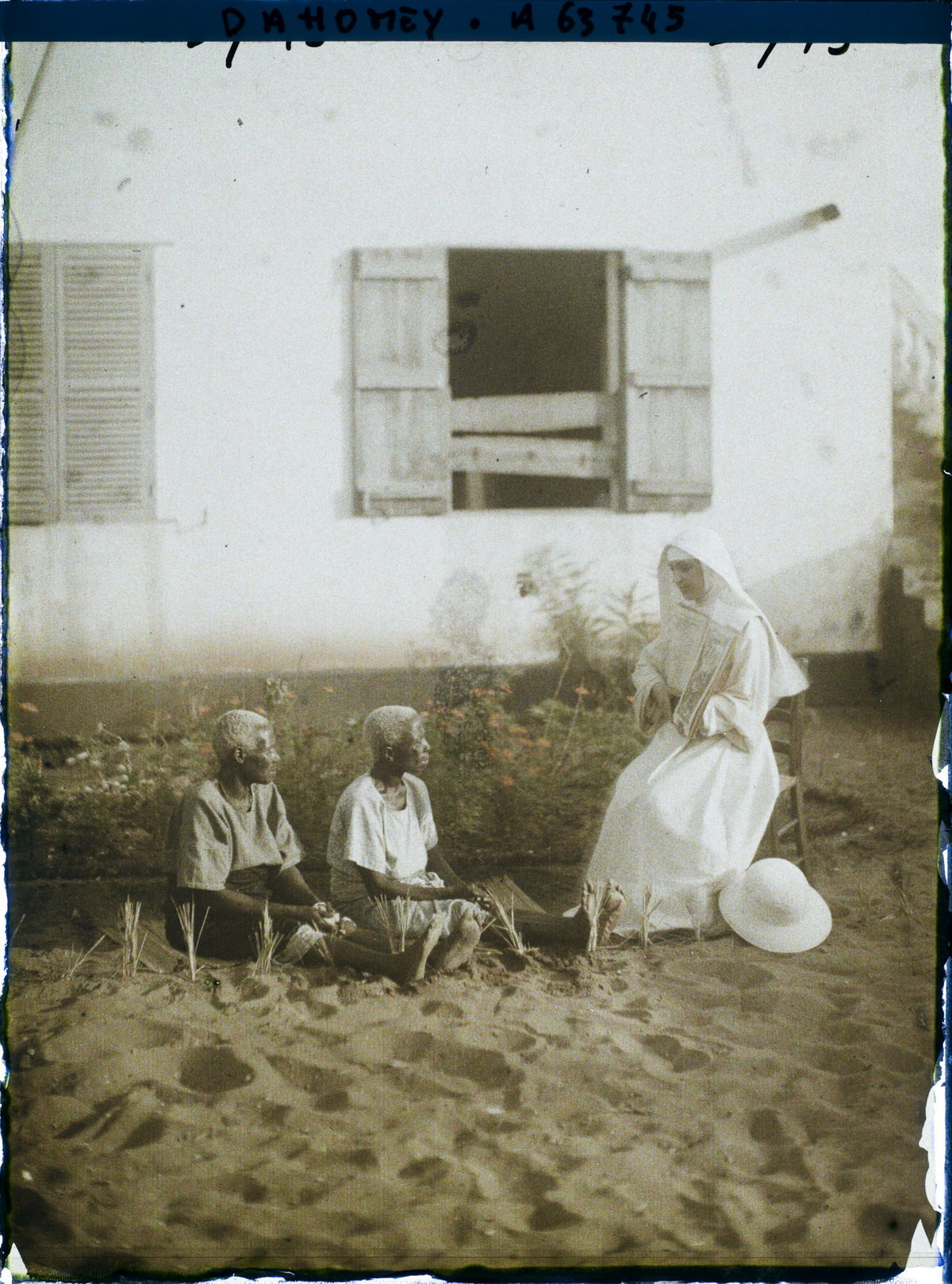 Một ma-sơ giảng đạo Cơ Đốc cho hai cụ bà người bản địa ở thị trấn ven biển Cotonou, Dahomey năm 1930. Ngày nay Cotonou là thành phố lớn nhất Benin. Ảnh: Frédéric Gadmer / Collections.albert-kahn.hauts-de-seine.fr.