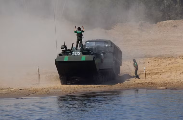 Diễn tập dùng xe lội nước chuyên dụng PTS đưa phương tiện cơ giới vượt sông.
