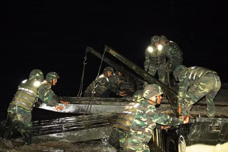 Trong đêm tối, lực lượng công binh lắp ghép phà và cầu phao bảo đảm cho các phương tiện vượt sông.