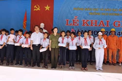 Thiếu tá Đinh Hương Bình - Phó Tổng Biên tập báo An ninh Thủ đô và ông Nguyễn Quang Trung – Phó TGĐ EVN HANOI trao tặng 1000 quyển vở cho các em học sinh có hoàn cảnh khó khăn tại trường THCS Dương Nội ngày 05/09/2014. Ảnh: Hải Minh.