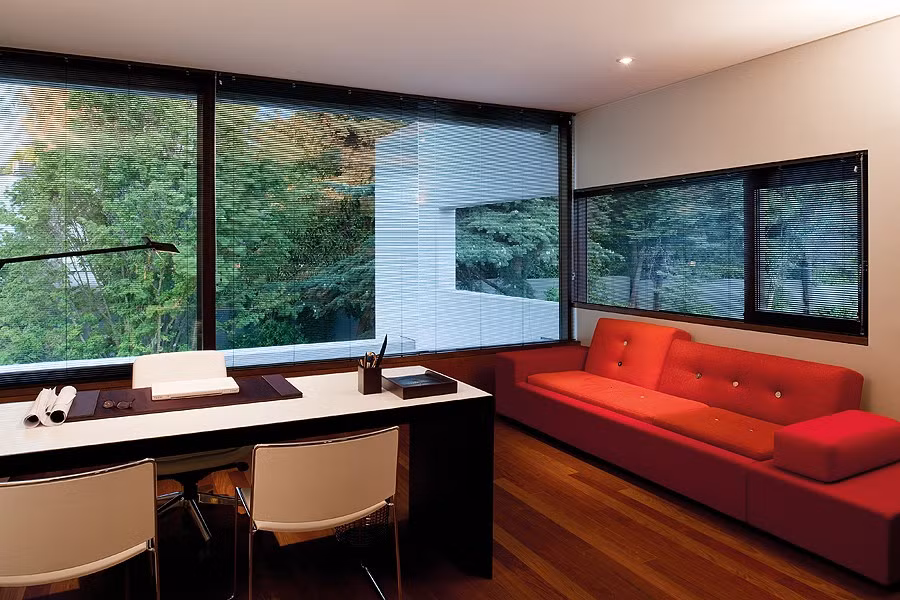 Nội thất trong phòng làm việc lấy hai màu nâu - đỏ làm chủ đạo. Các ô cửa sổ kính tấm lớn được thiết kế quanh phòng nhằm tận dụng tối đa ánh sáng tự nhiên vào ban ngày và tạo không gian mở cho căn phòng.