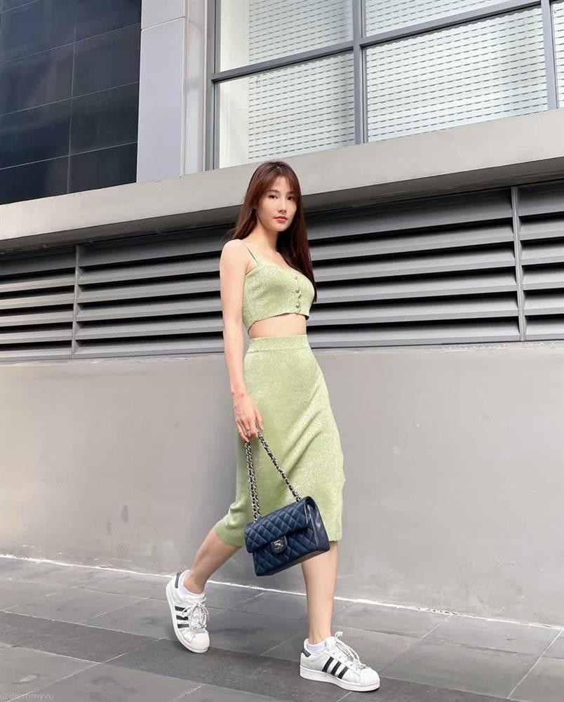 Diễm My 9X thả dáng nuột nà trên phố với set đồ được mix theo style matchy - matchy. Phối crop top cùng chân váy tiệp màu xanh lá, cô nàng điểm trang vẻ trẻ trung sành điệu cho diện mạo bằng phụ kiện giày thể thao và túi Chanel.