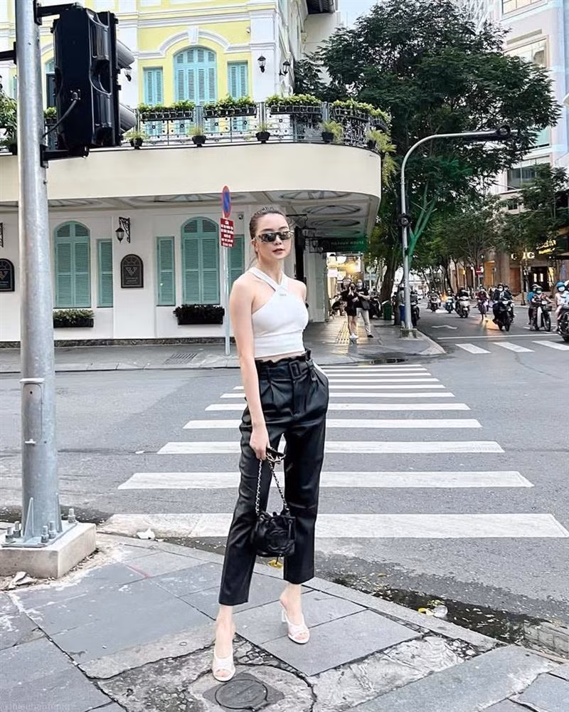 Lấy đen trắng làm kim chỉ nam, Thiều Bảo Trang chọn crop top cổ yếm, bắt cặp với quần da cá tính. Bên cạnh túi xách trẻ trung, người đẹp còn sử dụng giày cao gót để làm bật vẻ ngoài nữ tính, sang chảnh.