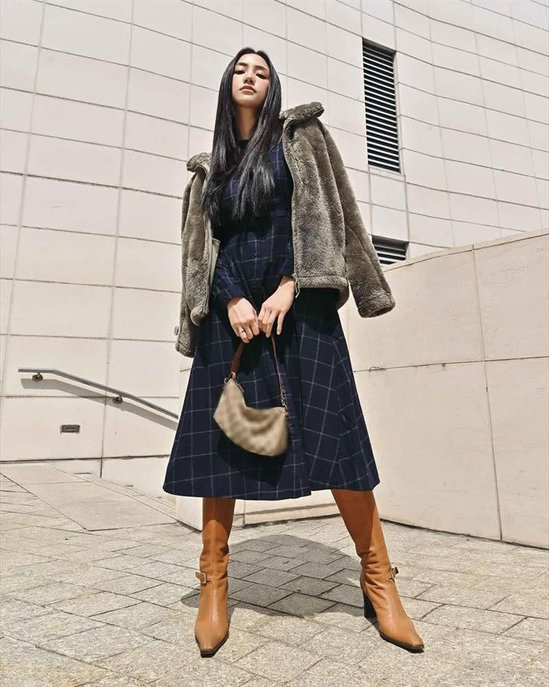 Salim chơi trội với style ấn tượng, phá cách. Cô nàng mix váy liền dáng dài với áo lông khoác hờ hững cùng boots da và túi xách tay.
