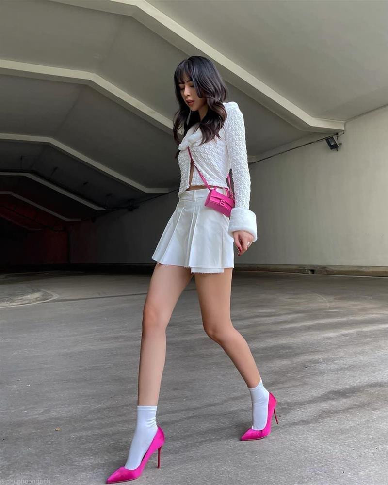 Phí Phương Anh nhấn nhá outfit tuyền trắng bằng phụ kiện túi xách và giày cao gót hồng neon chóe.