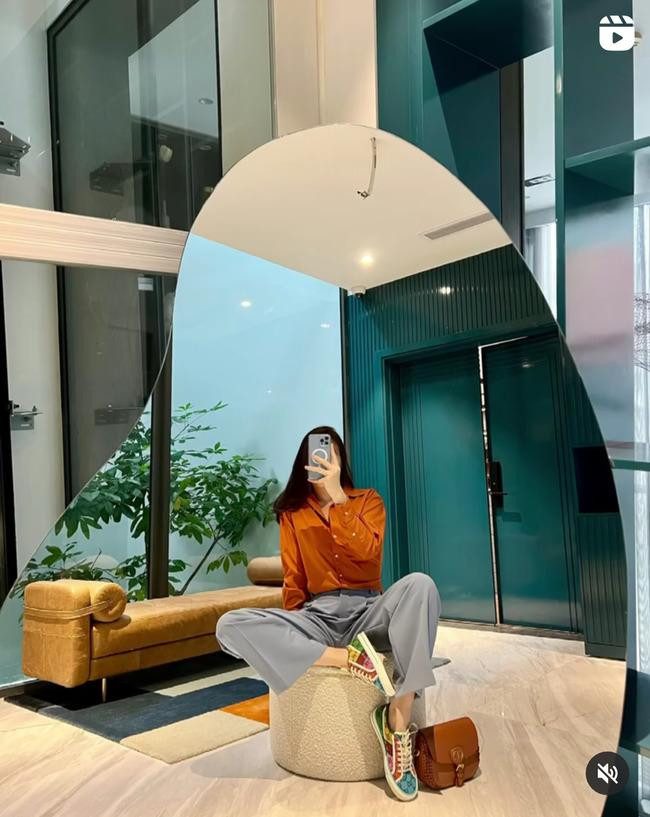 Mẹ 1 con mix áo sơ mi màu cam đất cùng quần âu ghi xám, đi giày sneaker không thể trẻ trung hơn. Phom dáng rộng của mẫu quần âu mang đến sự thời thượng cho bộ đồ, lại có thể kết hợp được với rất nhiều kiểu áo có sẵn trong tủ.