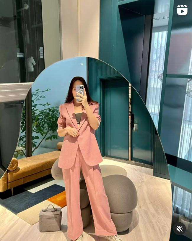 Bộ suit màu hồng pastel diện lên vô cùng ngọt ngào, tươi trẻ. Cô không mix cùng những items màu mè, sặc sỡ mà thay vào đó là mẫu áo crop top màu trung tính, cùng đôi giày sneaker nhã nhặn.