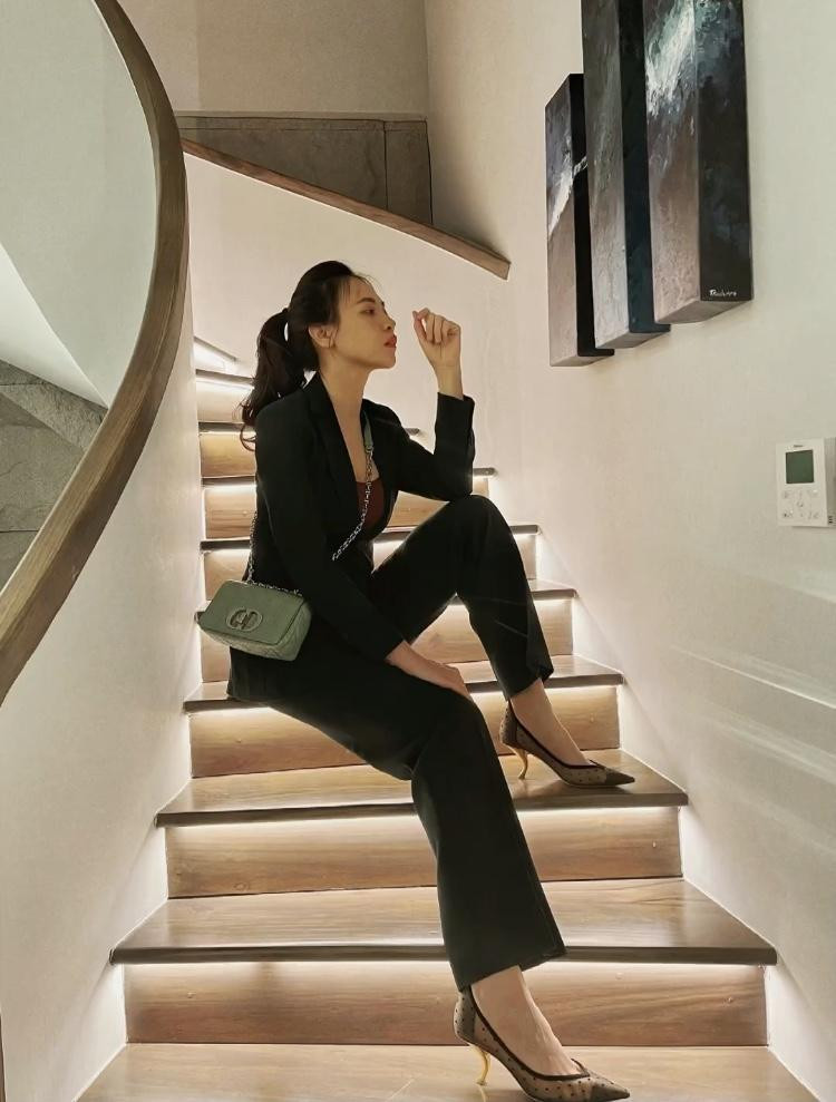 Đàm Thu Trang toát lên khí chất soái tỷ với bộ suit màu đen phối cùng áo bratop bên trong, giày cao gót và túi đeo chéo thời thượng.