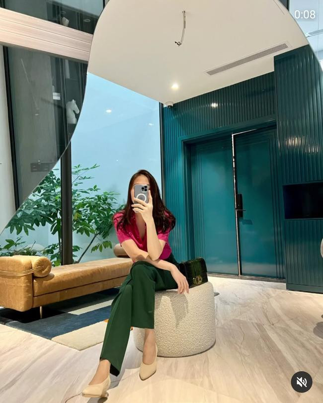 Áo sơ mi màu hồng và quần âu xanh lá đậm mang đến vẻ ngoài thanh lịch, trang nhã. Đàm Thu Trang đã rất cao tay khi chọn một đôi giày trắng gót thấp, thiết kế cổ điển để không phá vỡ đi sự hài hòa vốn có.