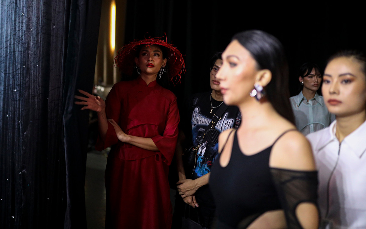 Trước khi ra sân khấu, Võ Hoàng Yến được chỉnh sửa lại lớp make-up, tô son đỏ đậm để ton sur ton với màu sắc trang phục. Là vedette nên siêu mẫu 33 tuổi sẽ bước ra runway cuối cùng, do đó, cô phải đứng nép vào góc cánh gà để nhường không gian cho dàn người mẫu đi trước mình.