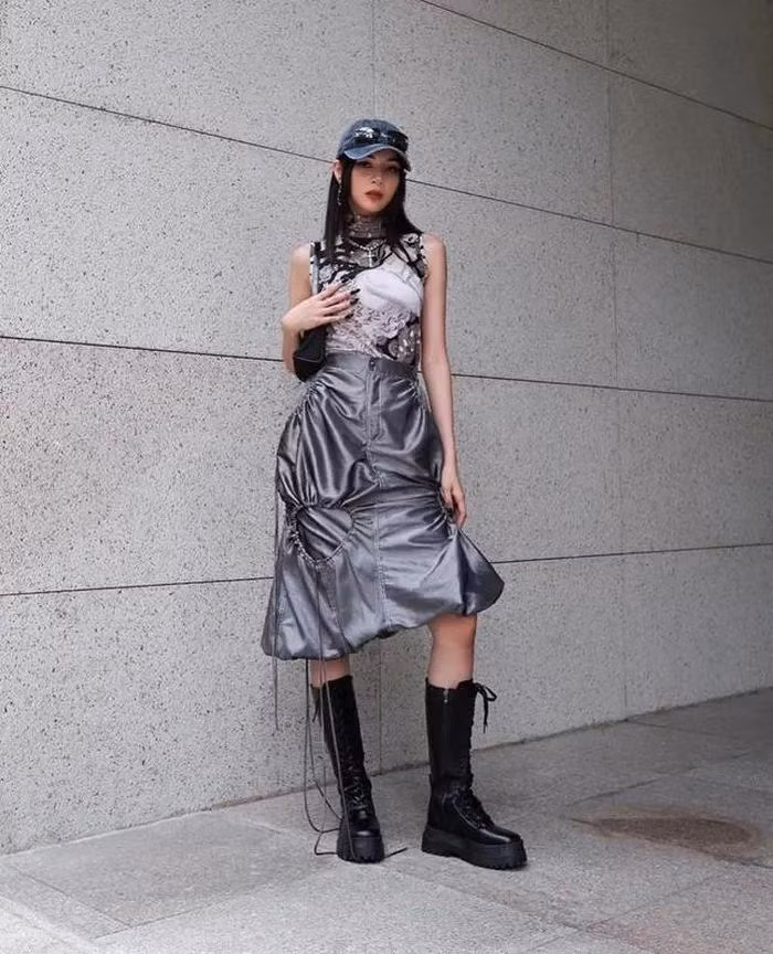 Phí Phương Anh xuống phố với set đồ hầm hố gồm áo tanktop cổ lọ và chân váy thiết kế lạ mắt.