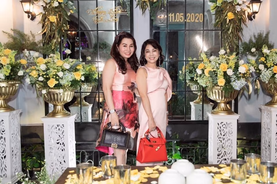 Trang phục của mẹ chồng Diệp Lâm Anh đều được kết hợp với những phụ kiện đắt tiền khác nhau như túi hàng hiệu, phụ kiện kim cương,... Như trên hình, chiếc Hermès Kelly màu đỏ có giá lên tới 500 triệu đồng được bà sử dụng khi đi tiệc và phối cùng trang phục ăn ý.