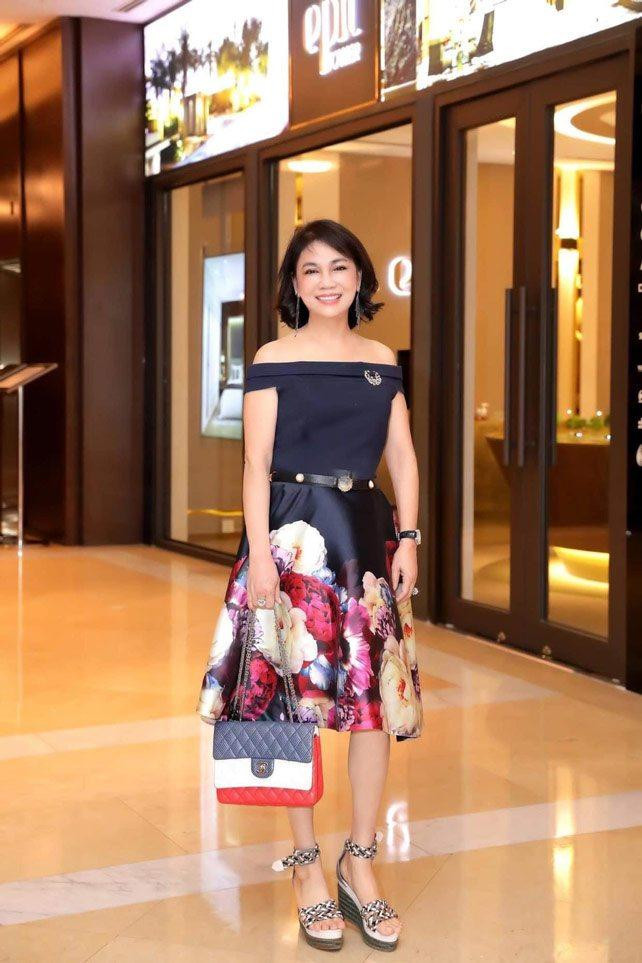 Nữ doanh nhân thêm trẻ trung và gợi cảm khi không ngại chọn diện váy hoạ tiết rực rỡ, đi sandal đế cao, mix với mẫu túi 3 màu xanh - trắng - đỏ tươi tắn của Chanel có giá gần 83 triệu đồng.