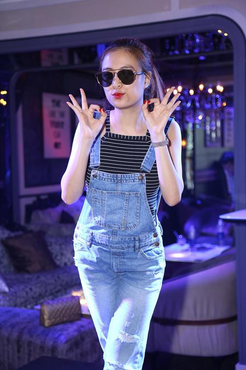 Hoàng Thùy Linh trở nên trẻ trung và xinh xắn hơn khi chọn quần jean yếm mặc cùng áo hai dây kẻ sọc nhỏ.