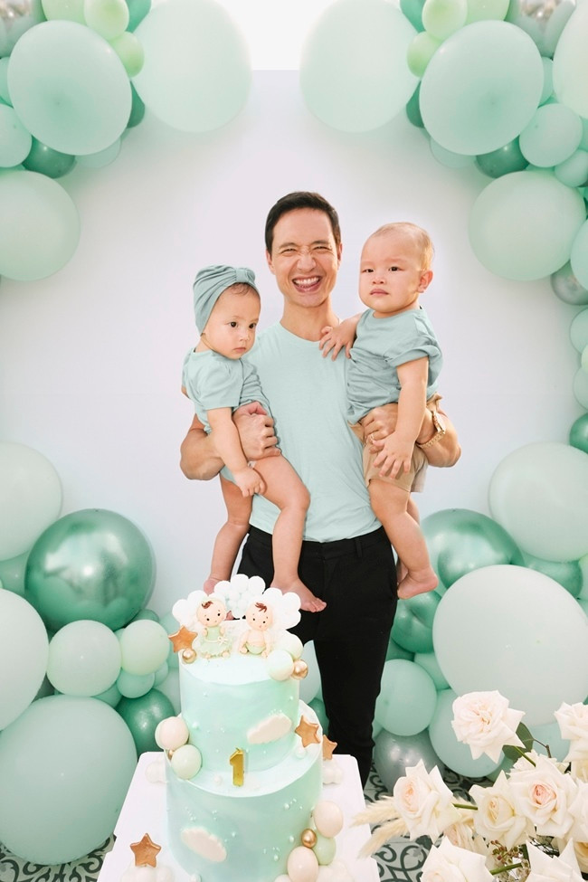 Kim Lý cười tít mắt, hai tay bế hai con. Trong nhiều video gia đình, Kim Lý không giấu được cảm xúc lần đầu làm bố khi chứng kiến những khoảnh khắc đáng nhớ của con. Anh thậm chí xúc động khi tỏ rõ sự lo lắng lúc nhìn thấy các con lần đầu được tiêm vắc xin.
