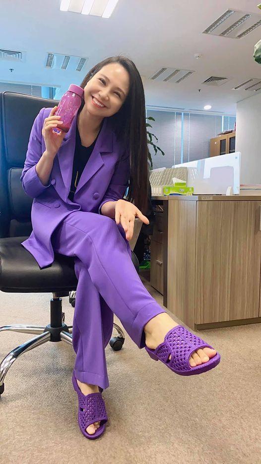 MC Mỹ Lan diện cả cây tím đi làm ngày mưa.