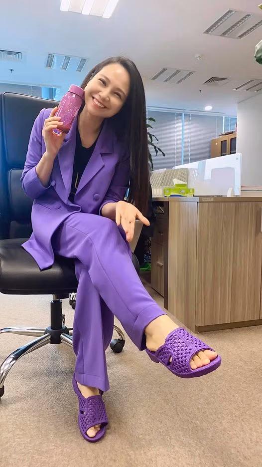 MC Mỹ Lan diện cả cây tím đi làm ngày mưa.