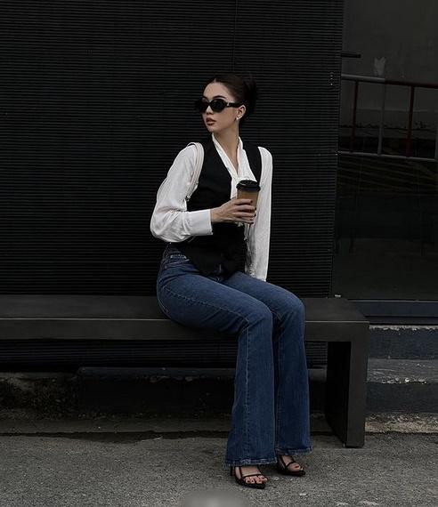 Một Ngọc Trinh kín đáo mà vẫn đủ sang chảnh. Mẫu nội y hóa quý cô Paris với áo sơ mi, gilet và quần jeans ống loe, sandals quai mảnh tôn dáng.