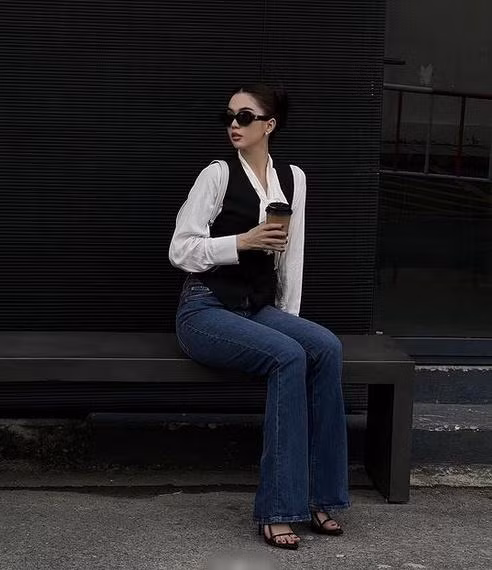 Một Ngọc Trinh kín đáo mà vẫn đủ sang chảnh. Mẫu nội y hóa quý cô Paris với áo sơ mi, gilet và quần jeans ống loe, sandals quai mảnh tôn dáng.