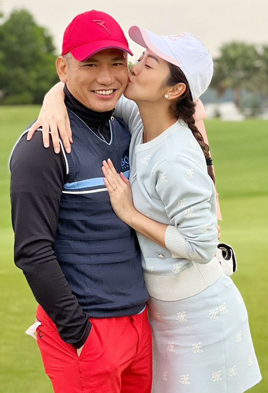  Jennifer Phạm kiễng chân hôn má chồng giữa sân golf trước sự chứng kiến của bạn bè. Đã có gần 10 năm chung sống và ba con, vợ chồng cô vẫn giữ được sự ngọt ngào như thủa ban đầu. Cả hai có nhiều sở thích chung, trong đó có golf. Khi ở nhà tránh dịch, họ vẫn chăm chỉ luyện tập cùng nhau.