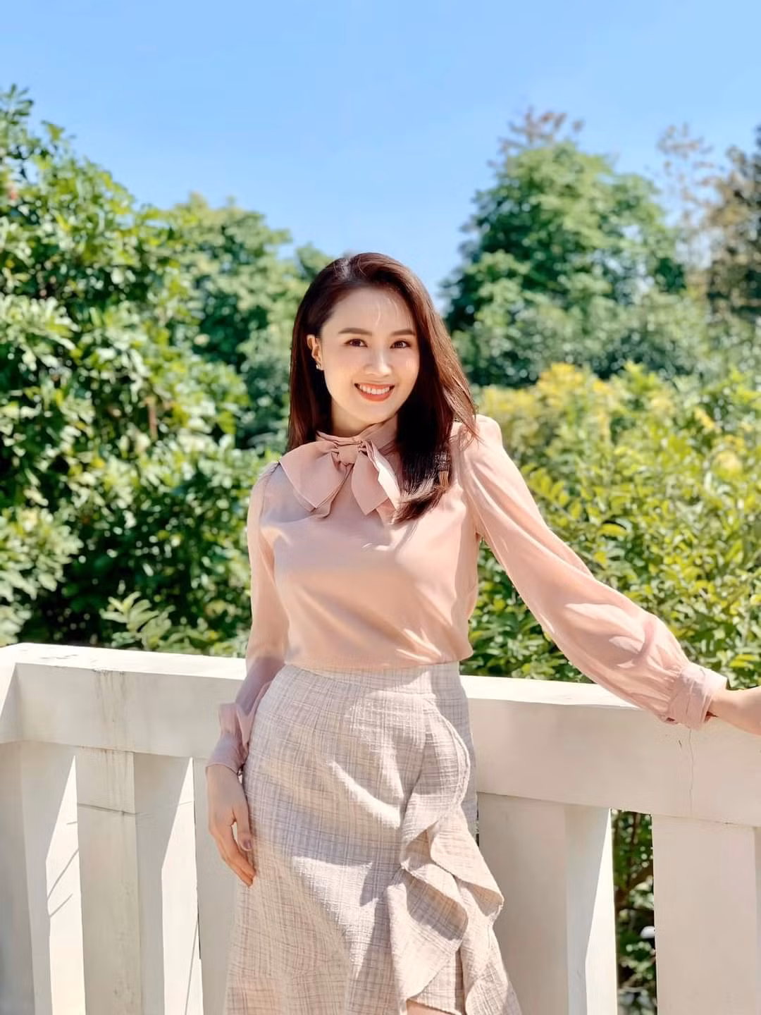  Hồng Diễm chụp ảnh bên ban công đầy nắng.