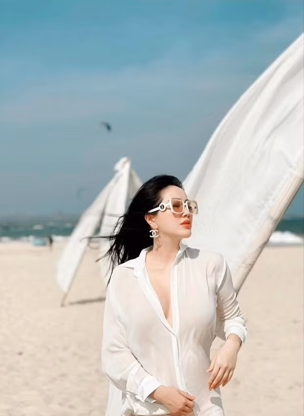 Cô diện áo sơ mi trắng mỏng manh và liên tục tạo dáng lấy tay che bụng.