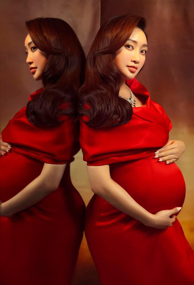 à xã Chi Bảo lựa chọn thiết kế trễ vai, chất liệu lụa satin khoe bụng bầu tròn xoe vượt mặt.