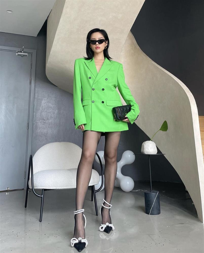 Khánh Linh nhận nhiều lời khen nhờ lối mix đồ phù hợp với thị hiếu của giới trẻ. Để tăng vẻ sành điệu và bí ẩn, cô chọn tông đen gồm quần tất, túi xách, mắt kính và giày cao gót khi kết hợp với blazer màu xanh lá theo kiểu giấu quần.