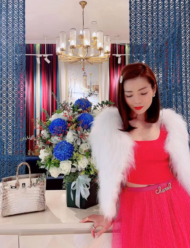 Với nguyên cây hồng thắm, Lệ Quyên cũng pose dáng e ấp, nhu mì đến lạ thường. Không thể thiếu các món đồ hiệu được cô khoe khéo: Từ túi Birkin bạch tạng bạc tỷ, cài áo Chanel đến đồng hồ kim cương.