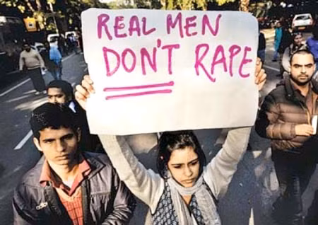 Một cô gái giơ cao khẩu hiểu "Những người đàn ông thực sự sẽ không cưỡng hiếp" trong một cuộc biểu tình chống nạn cưỡng hiếp ở Ấn Độ.