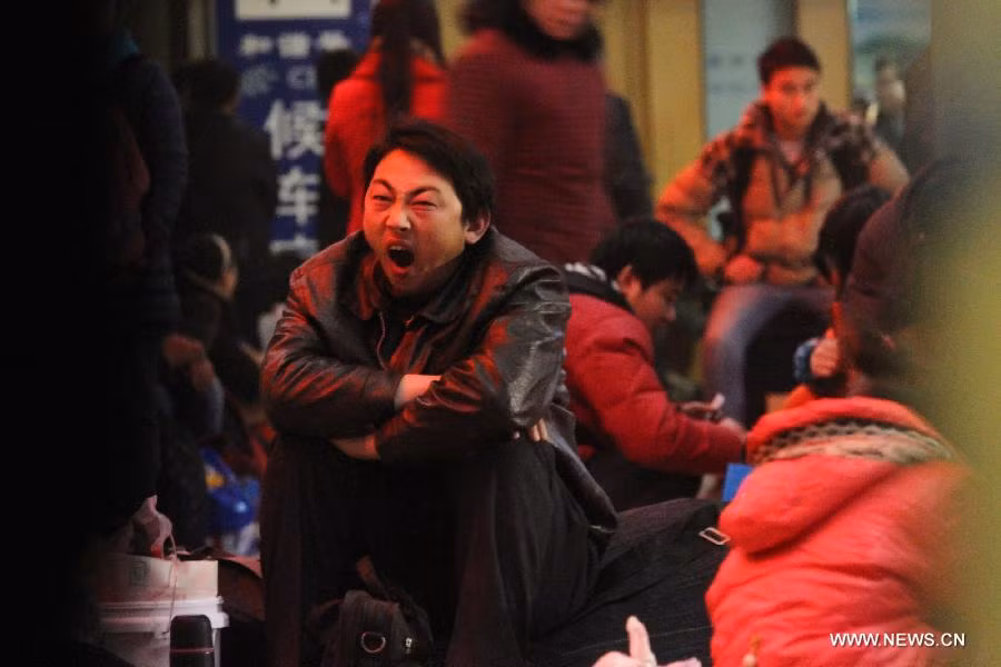 Một người đàn ông tỏ ra mệt mỏi khi ngồi đợi tàu ở nhà ga Thường Châu tại thành phố Thường Châu, tỉnh Giang Tô.