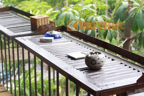 Những cánh cửa gỗ cũ được tận dụng làm thành chiếc bàn gắn trên lan can. Khách ngồi đây có thể vừa ăn uống và ngắm cảnh đường phố.