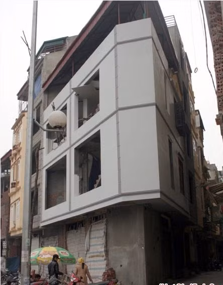 Ngôi nhà có hình thù siêu méo này được gia chủ "khéo léo" tận dụng không gian vỉa hè và ngõ để cơi nới trên tầng 2. Trên đoạn đường này nhiều ngôi nhà còn được gia chủ nắn chỉnh uốn lượn theo đường cong của tuyến đường.