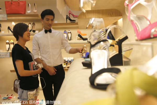 Một người mẫu nam đang chọn giày cho khách hàng.