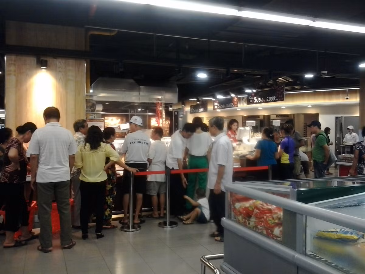 Mặc dù có nhiều quán hàng ế ẩm song tại Lotte, nhiều gian hàng vẫn đang hút khách. Trong ảnh là cảnh khách đứng xếp hàng chờ mua gà quay giảm giá.