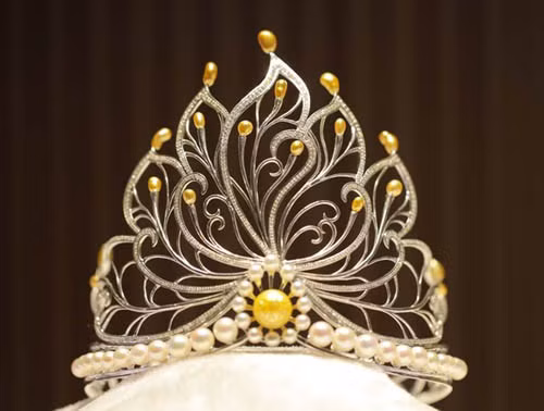 Theo Ban tổ chức, đây là vương miện đính viên ngọc trai trống đồng lớn nhất và có nhiều ngọc trai tự nhiên nhất. Vương miện đính viên ngọc trai trống đồng và 18 viên ngọc trai tự nhiên quý hiếm được sưu tầm 10 năm nay. Đồng thời, các nghệ nhân đã khắc họa hình ảnh hoa sen lên vương miện, với chất liệu vàng trắng và 1.000 viên kim cương tự nhiên, cùng nhiều hoa văn.