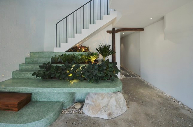 Chọn một khu vườn khô kiểu Nhật với đá mộc được sắp đặt có chủ ý dọc theo cầu thang đá mài xanh ngọc - kiểu cầu thang quen thuộc trong kiến trúc nhà phố cũ. Dẫn lối lên các tầng phía trên là các phòng lưu trú có đầy đủ tiện nghi khép kín.