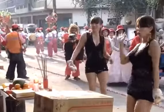 Hai cô gái trẻ, ăn mặc sexy dẫn đầu đoàn rước, đi đến các nhà dân để xin tiền.