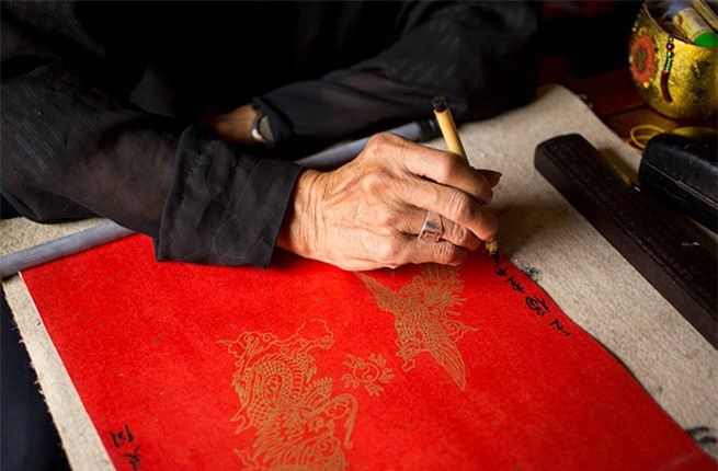 Một cụ đồ đang viết chữ thư pháp tại đền Ngọc Sơn nằm bên Hồ Hoàn Kiếm, Hà Nội.