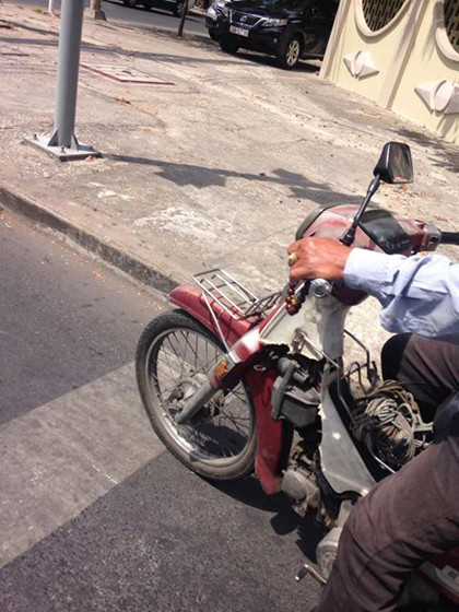 Chú cho xe đậu đúng vạch phân cách rồi từ từ bỏ xâu chuỗi xuống tay, lần từng hạt, từ tốn như không có chuyện gì... Ảnh: Trần Ngọc Ần.