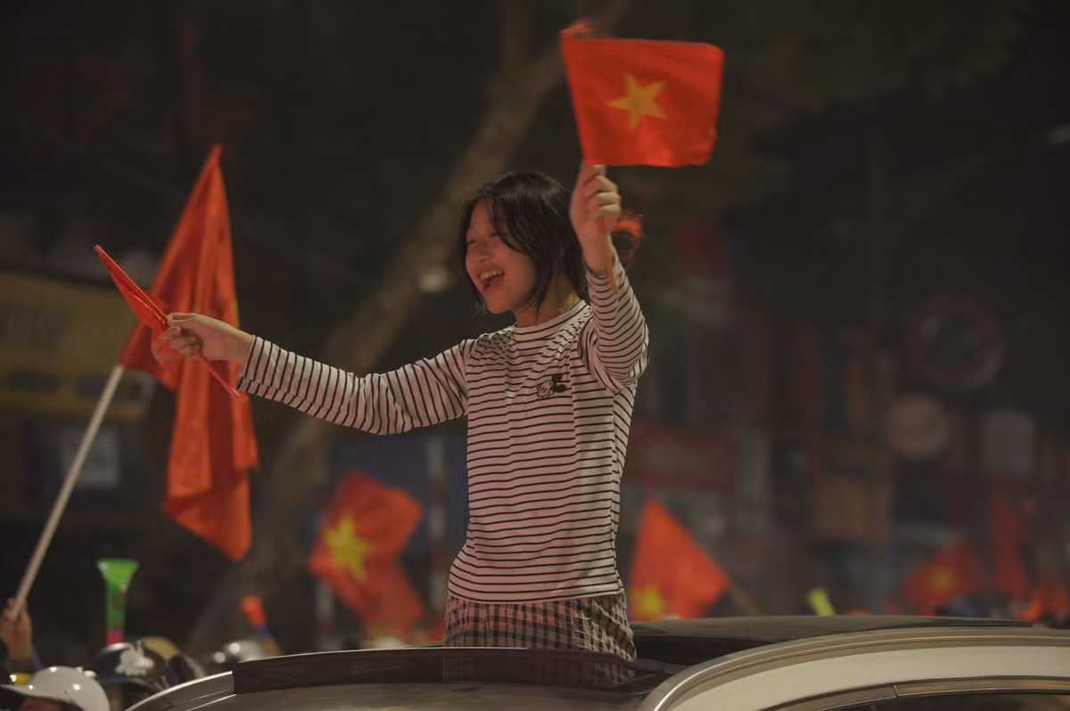 Người dân cầm theo cờ, kèn và các vật cổ vũ đổ ra đường sau khi xem trận chung kết lượt đi. 