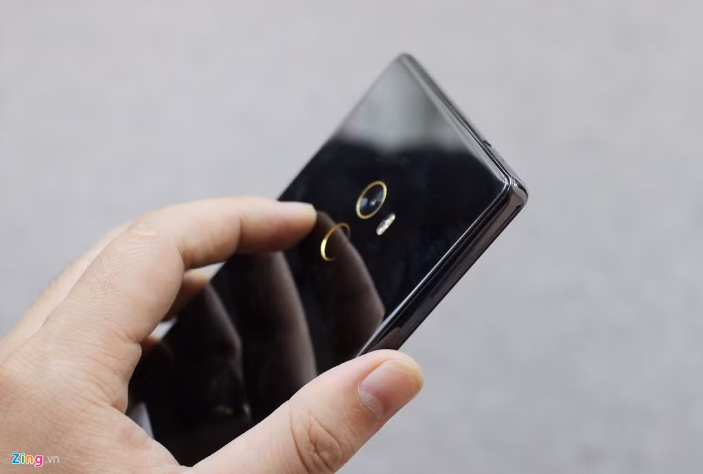 Mi Mix sử dụng mặt lưng bằng chất liệu gốm, tạo cảm giác cao cấp. Viền của máy cũng được làm đen bóng, hợp tông với lưng máy. Phần viền camera và cảm biến vân tay có màu vàng, tạo điểm nhấn.