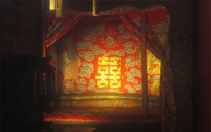Giường vua nằm (long sàng) được trang trí cầu kỳ, thêu long-phụng với chữ song hỷ màu vàng trên nền đỏ rực rỡ.
