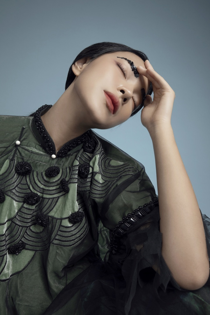 Những hoạ tiết từ tranh cổ được thêu nổi 3D song lại mang màu sắc mờ ảo, cuốn hút khi thấp thoáng sau lớp vải voan mỏng tang tựa làn sương khói. Lối trang điểm độc đáo cùng mái tóc rẽ ngôi, búi cao đậm nét quý phái của phụ nữ Á Đông. Biểu cảm sắc lạnh của Châu Bùi khiến thiết kế thêm nổi bật và hấp dẫn người nhìn.