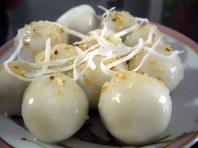 Tùy theo sở thích của mỗi người, có thể rắc thêm vài sợi dừa nạo nhỏ, hoặc dăm hạt đỗ xanh thổi chín còn nguyên hình hoa cau. Bát bánh sẽ trông như một đóa hoa cánh trắng, nhụy vàng, phủ dưới làn nước trong và thơm ngát.