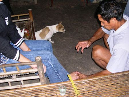 Thầy Năm Phờ đang dùng bùa ngải trị sưng trật cho bệnh nhân.