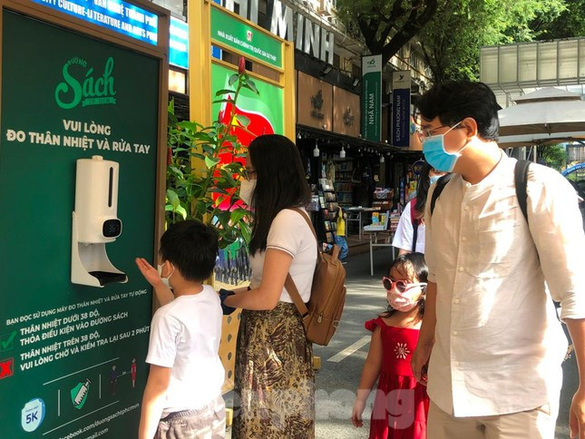 Trẻ em thích thú khi được đo thân nhiệt tự động bằng bàn tay.