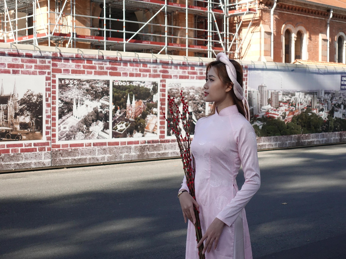 Tại khu vực trung tâm TPHCM như: Bưu điện trung tâm, Nhà thờ Đức Bà,... từ sáng sớm, nhiều bạn trẻ đã xúng xính áo hoa đến để chụp ảnh, ghi lại khoảnh khắc đẹp ngày đầu năm mới.