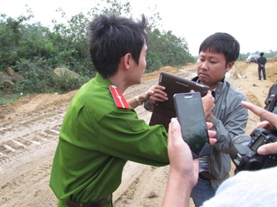 Một chiến sĩ công an ngăn cản PV tác nghiệp.