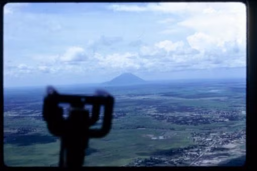 Núi Bà Đen ẩn hiện ở đường chân trời, nhìn từ một chiếc trực thăng chiến đấu. Ảnh: Terry Vaughn.